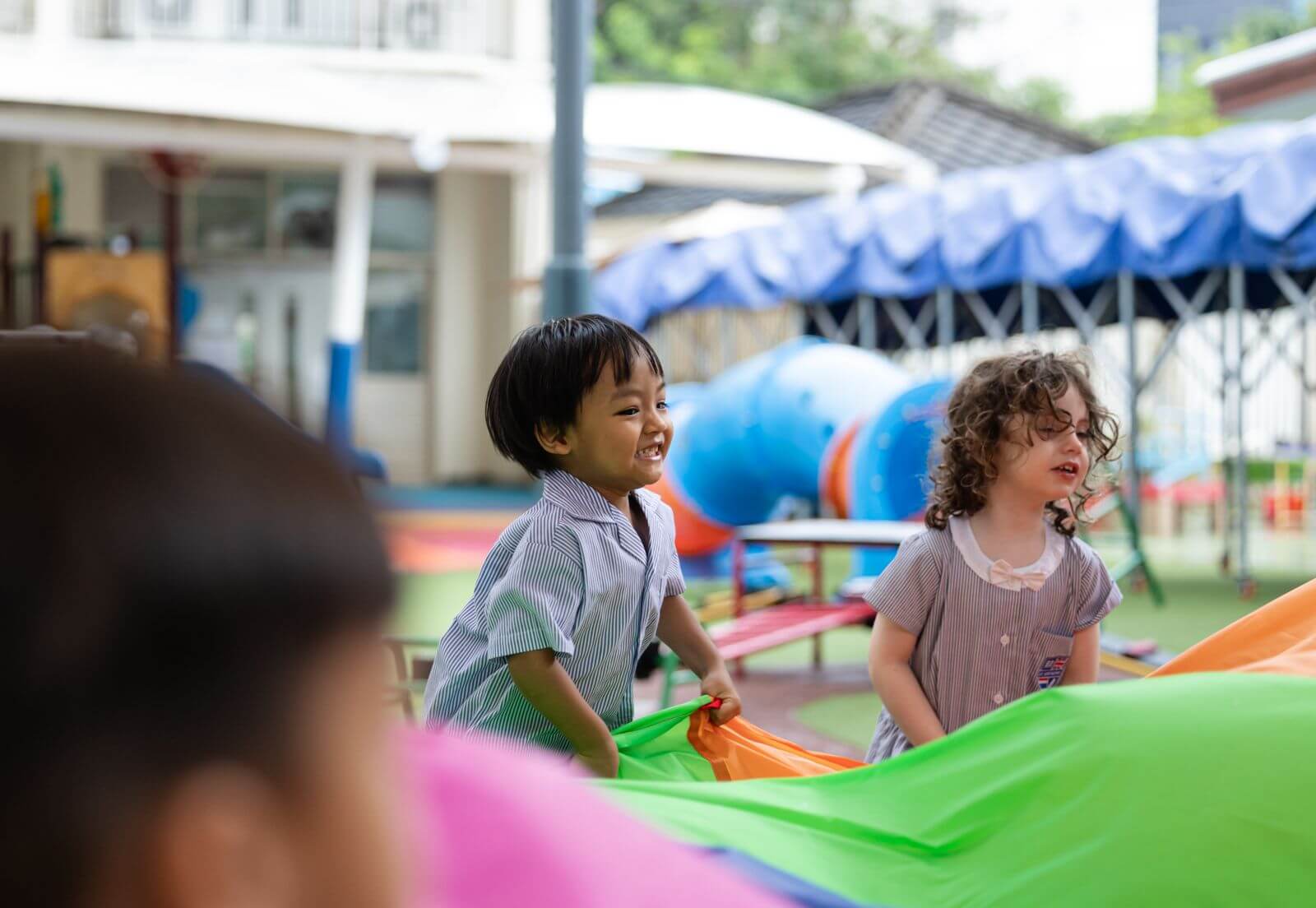 Kindergarten (K1) children playing together outdoors at St. Andrews Sathorn