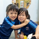 Two Kindergarten children hugging in their Early Years classroom at St. Andrews International School Sathorn